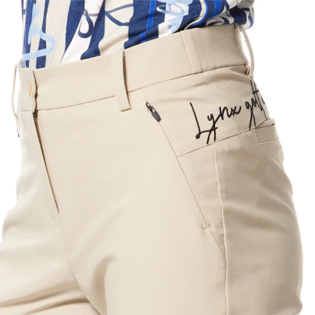 【Lynx Golf】女款日本進口布料抗UV接觸冷感機能織帶剪接設計草寫繡花造型窄管九分褲(卡其色)